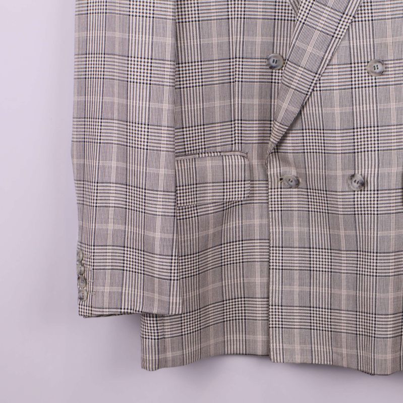 Nedre del och ärmslut på rutig kavaj med knappar