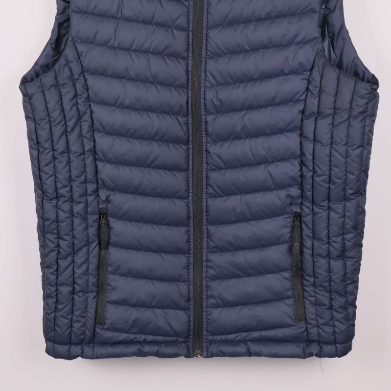 Närbild av västens nederdel med fickor och dragkedjor