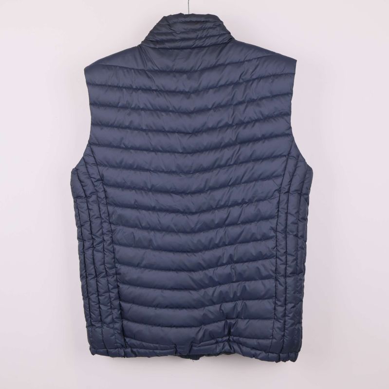 Baksida av blå quiltad väst med horisontella sömmar