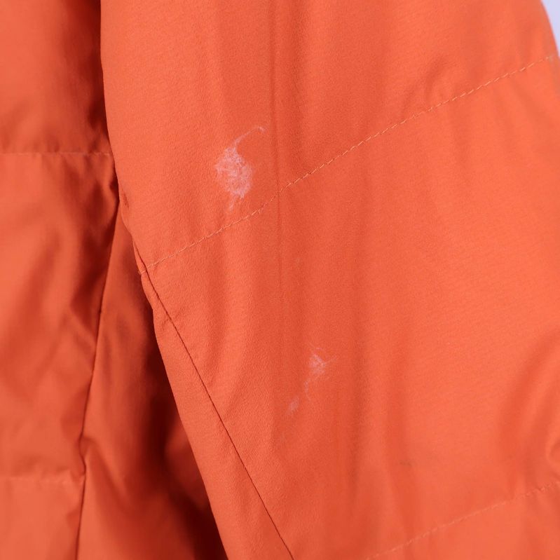 Närbild på fläckar på orange jackas högra ärm