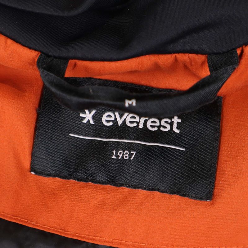 Närbild på Everest-märke och storlek M i jackans krage