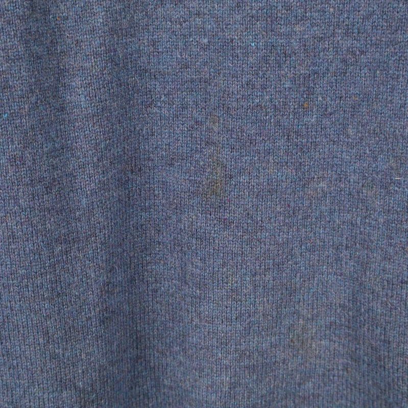 Närbild på stickat tyg med melerad blå färg