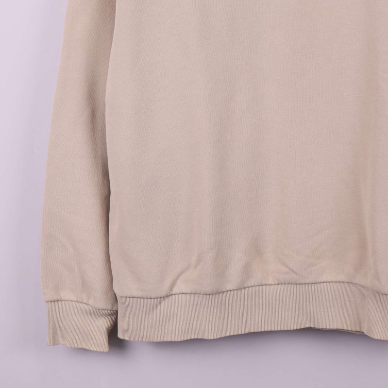 Närbild på nederkant och mudd på beige sweatshirt