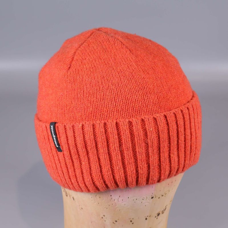 Orange mössa fotad bakifrån på skyltdocka