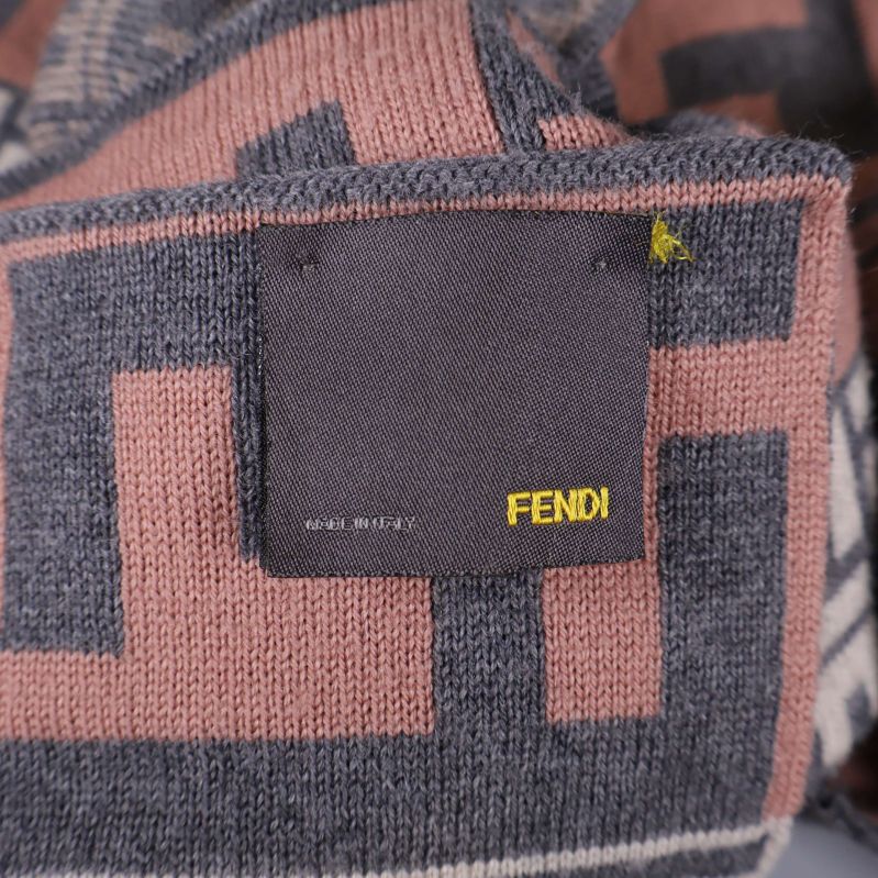 Fendi-etikett i gult på svart tygbit insydd i halsduken