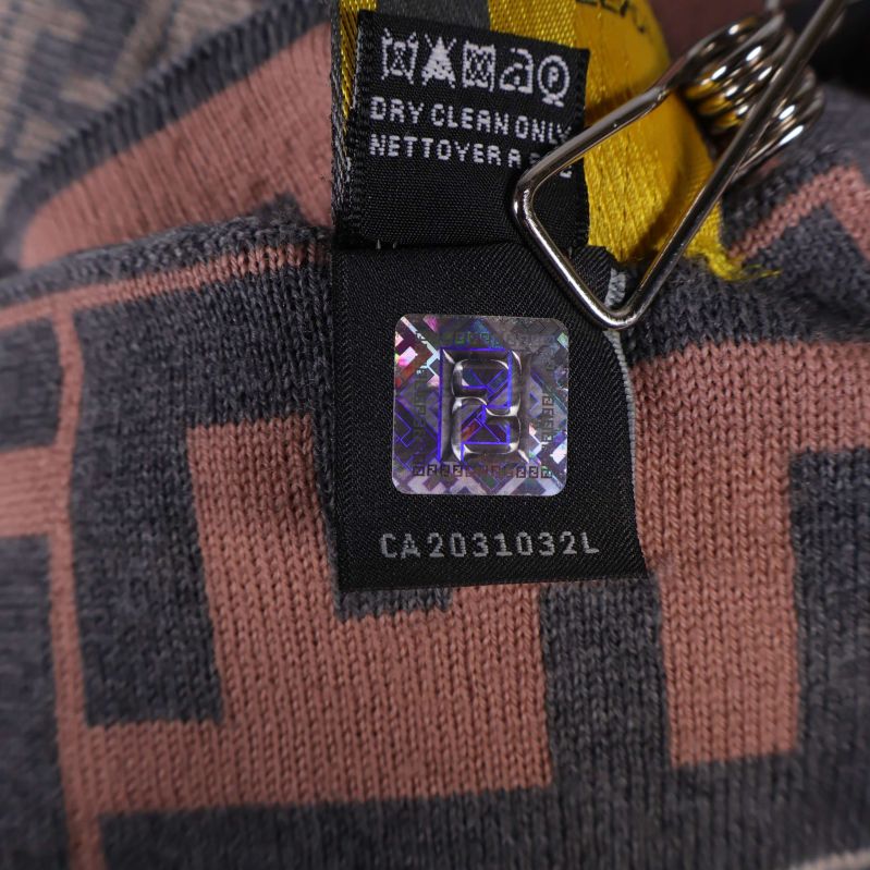 Närbild på hologram och skötselråd på halsdukens etikett