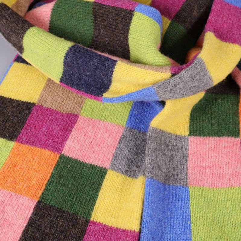 Närbild på stickningen och rutmönster i olika färger