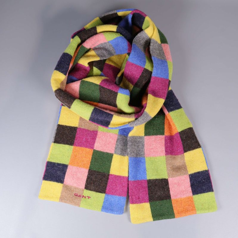 Färgglad rutig halsduk upplagd i en ring på grå bakgrund