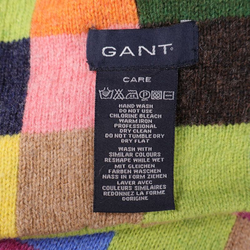 Material- och tvättetikett från GANT syns på färgad halsduk