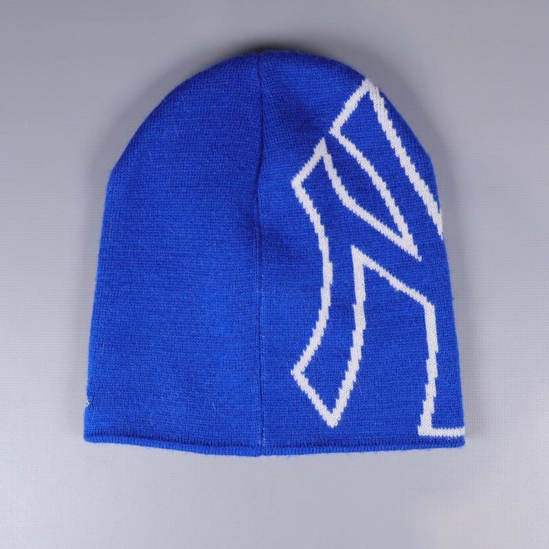 Blå mössa bakifrån med vit logodetalj på sidan
