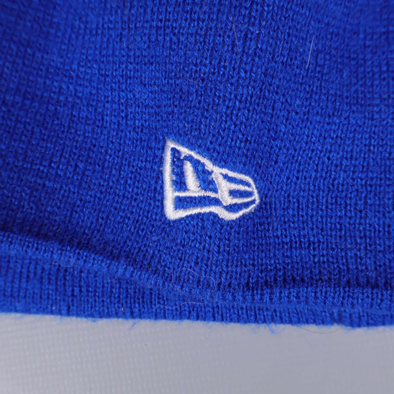 Närbild av vit New Era broderad logotyp på mössan