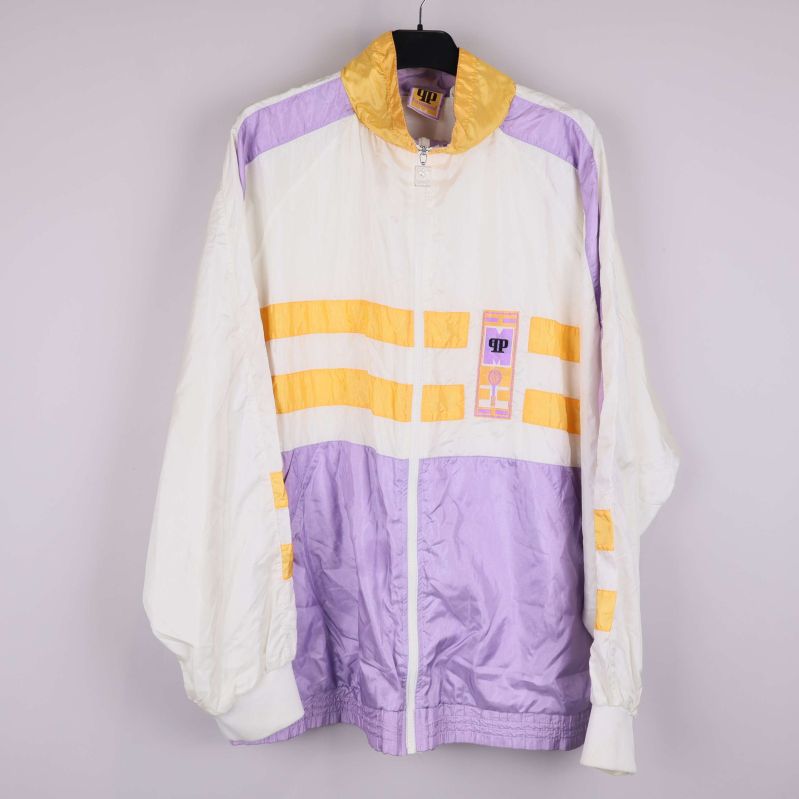 Vindjacka med vita, gula och lila färgblock hänger på galge