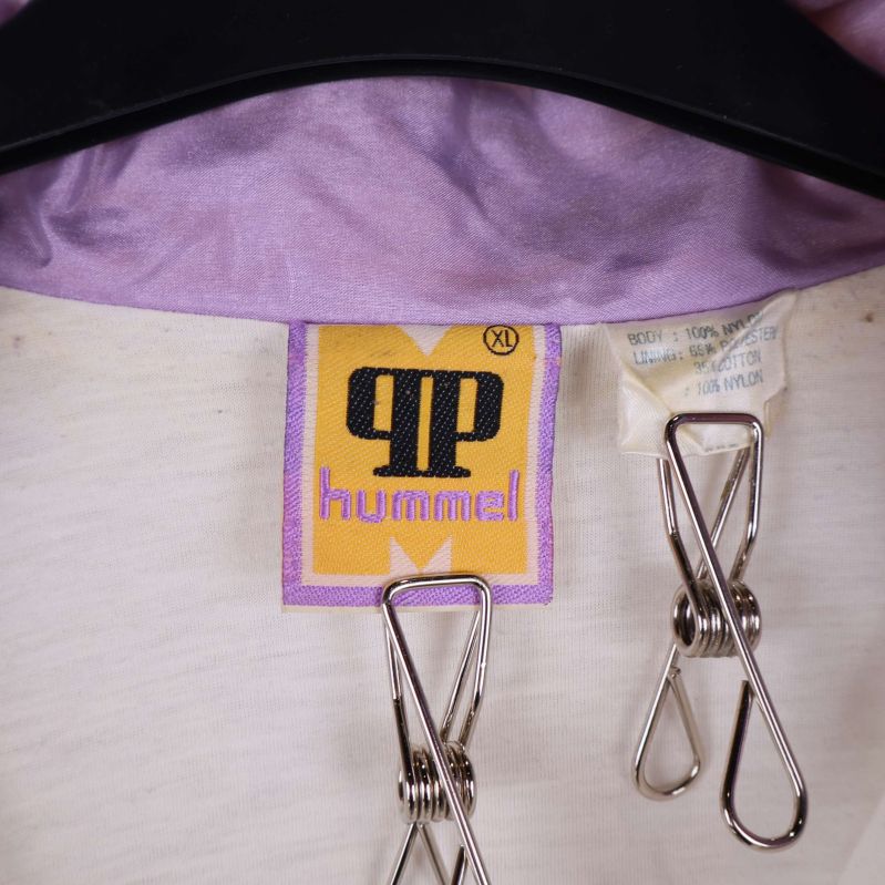 Närbild på kragtags med hummel-logotyp och storlek XL