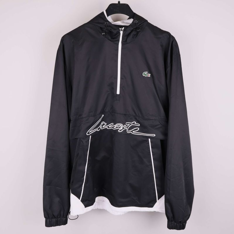 Svart och vit Lacoste vindjacka med huva hänger på galge