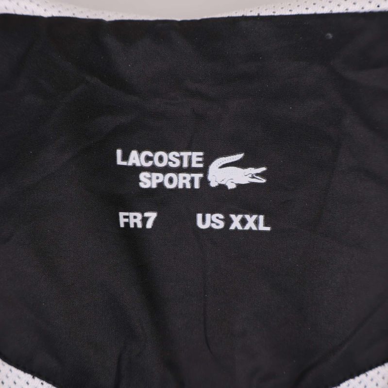 Närbild på Lacoste Sport storleksmärkning i jackans krage