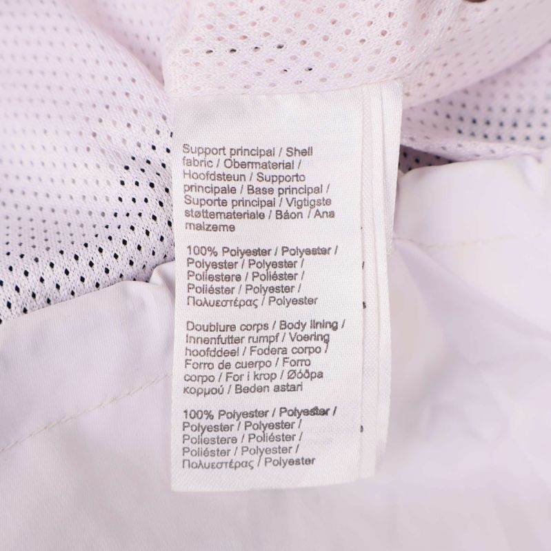 Materiallapp visar 100% polyester på flera språk med meshfoder synligt