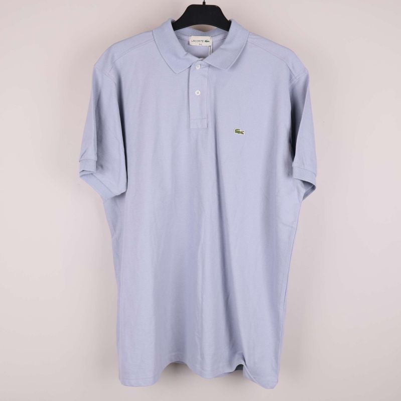 Ljusblå pikétröja med krage och krokodillogga på bröstet