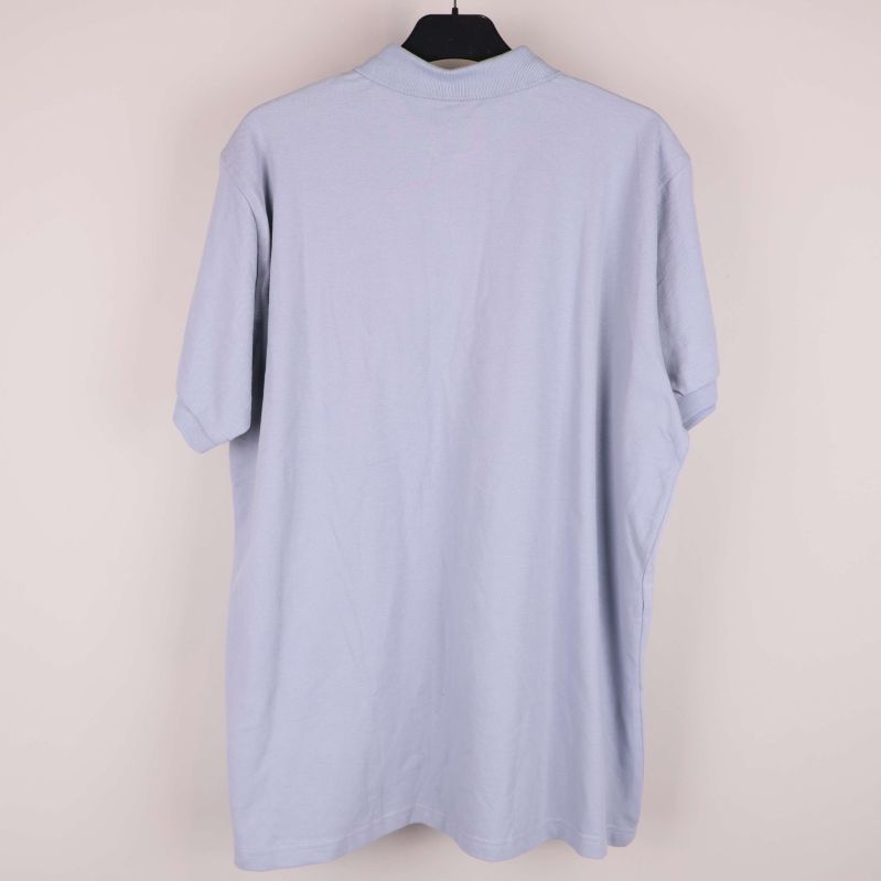 Baksidan av ljusblå pikétröja utan detaljer