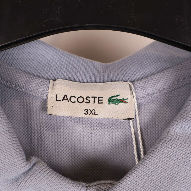 Närbild på Lacoste-etikett med storlek 3XL synlig