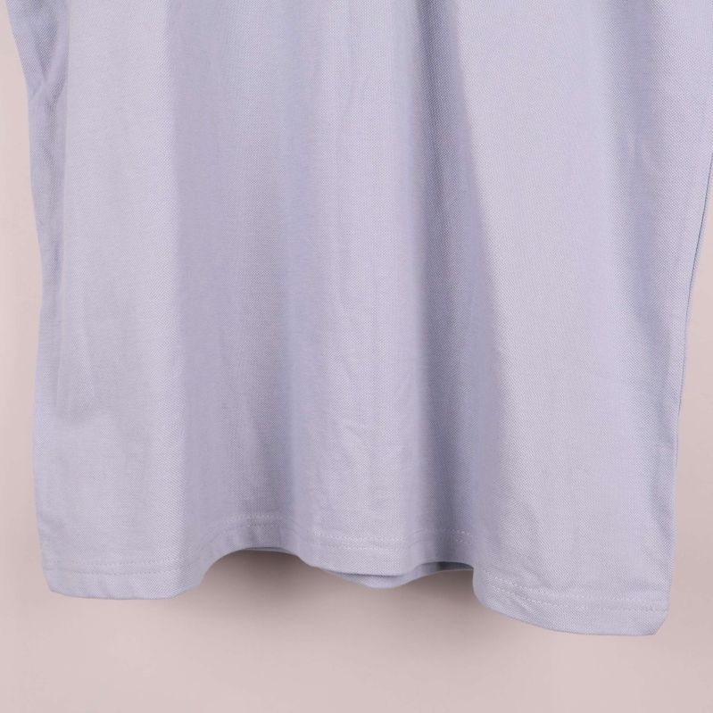 Nedre del av ljusblå pikétröjans framsida