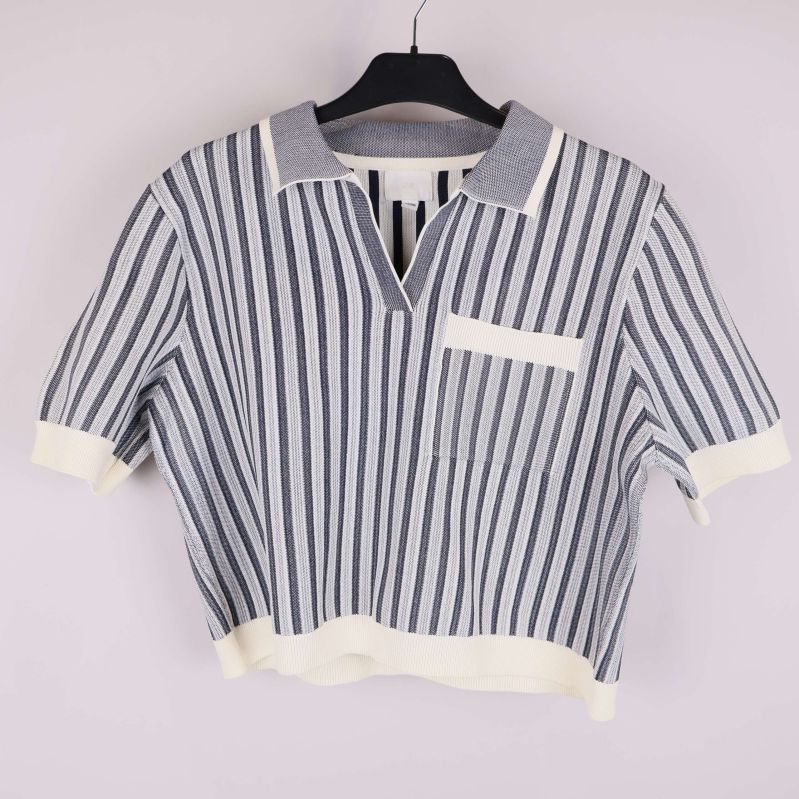 Stickad topp med blå och vita vertikala ränder på galge