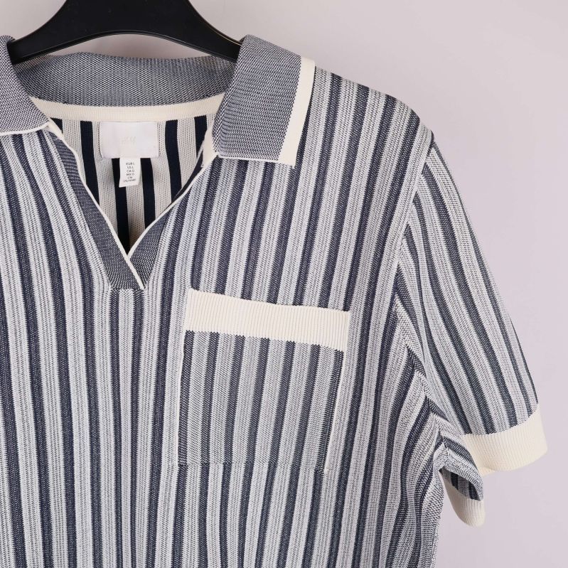 Närbild på bröstficka och krage på stickad topp