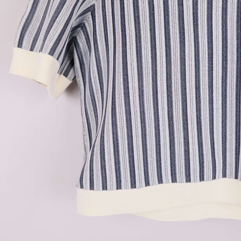 Närbild på nederkant och ärmslut med vita ribbade detaljer