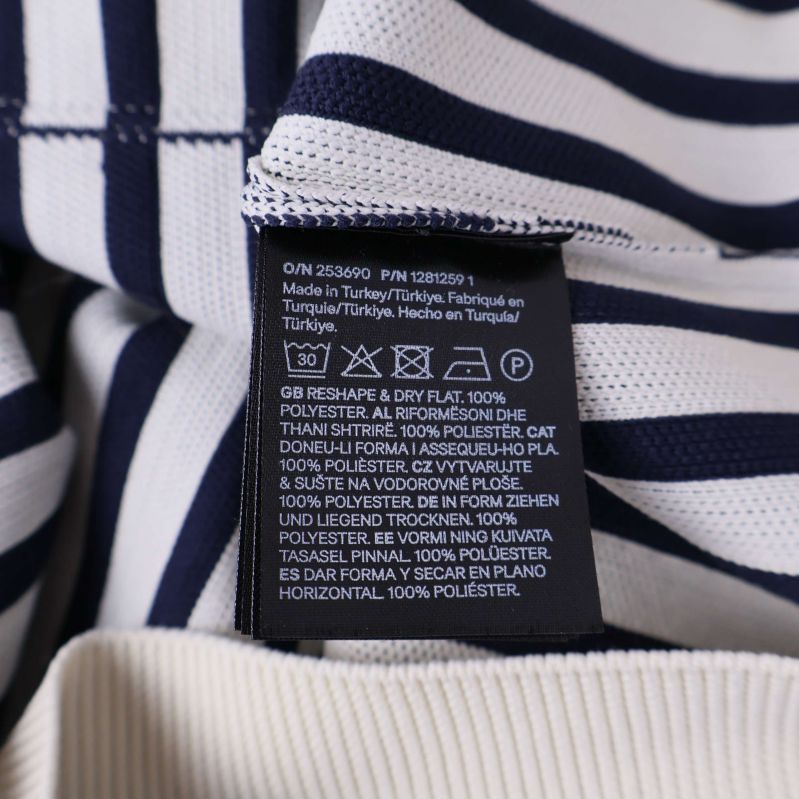 Materialetikett som visar 100 procent polyester