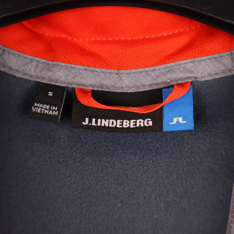 Närbild på J.Lindeberg märkning och storleksetikett i nacken