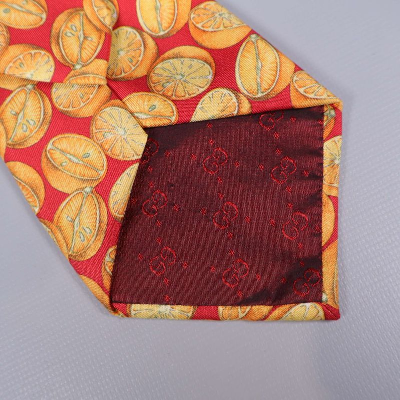 Detalj på slipsens spets med djupröd foder och logga