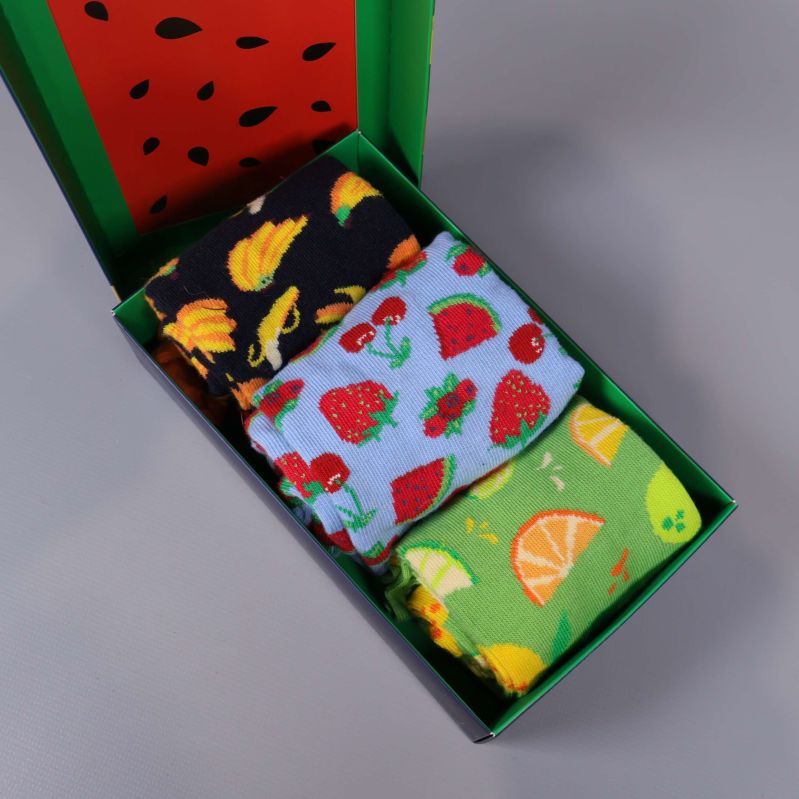 Tre par strumpor med fruktmönster i öppen ask