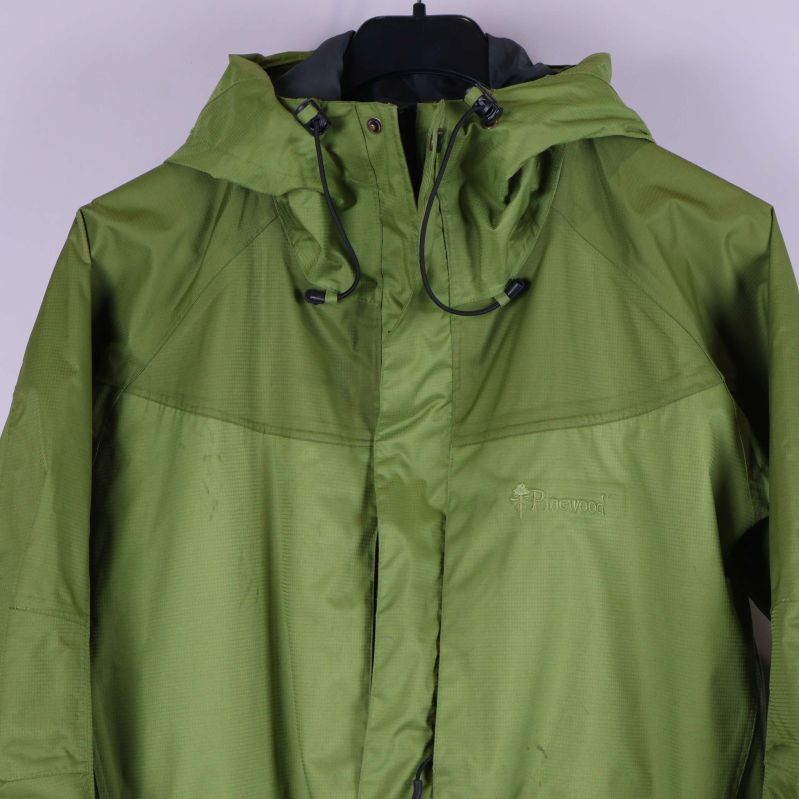 Framstycke av grön skaljacka med detaljerad huva