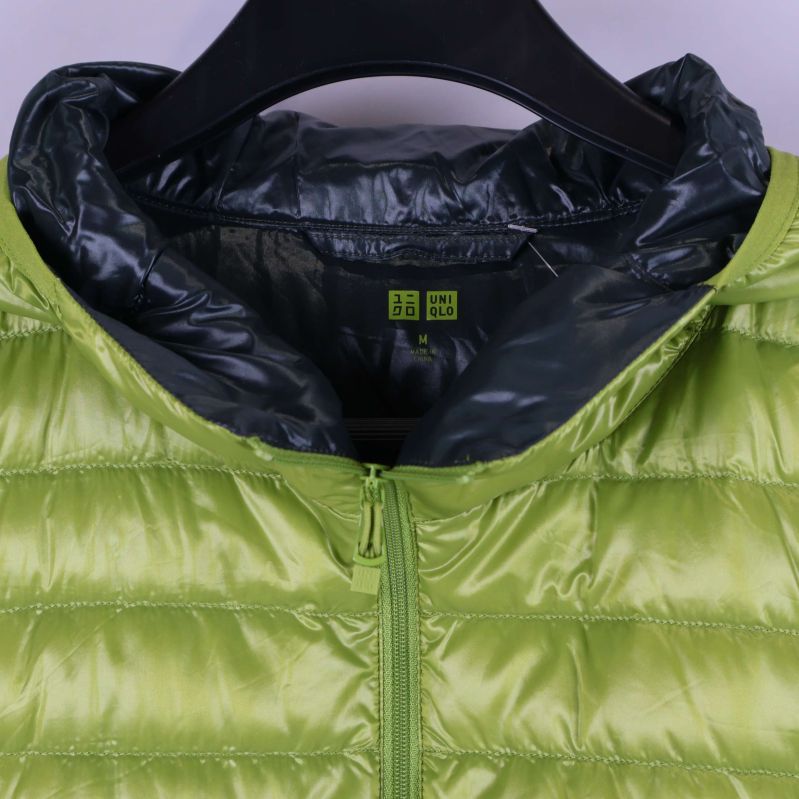 Närbild på övre delen av jacka med dragkedja och märkningsdetaljer