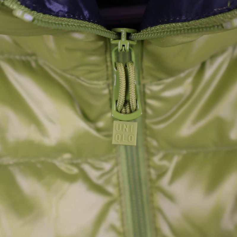 Närbild på Uniqlo-märkt dragkedja och jackans tyg