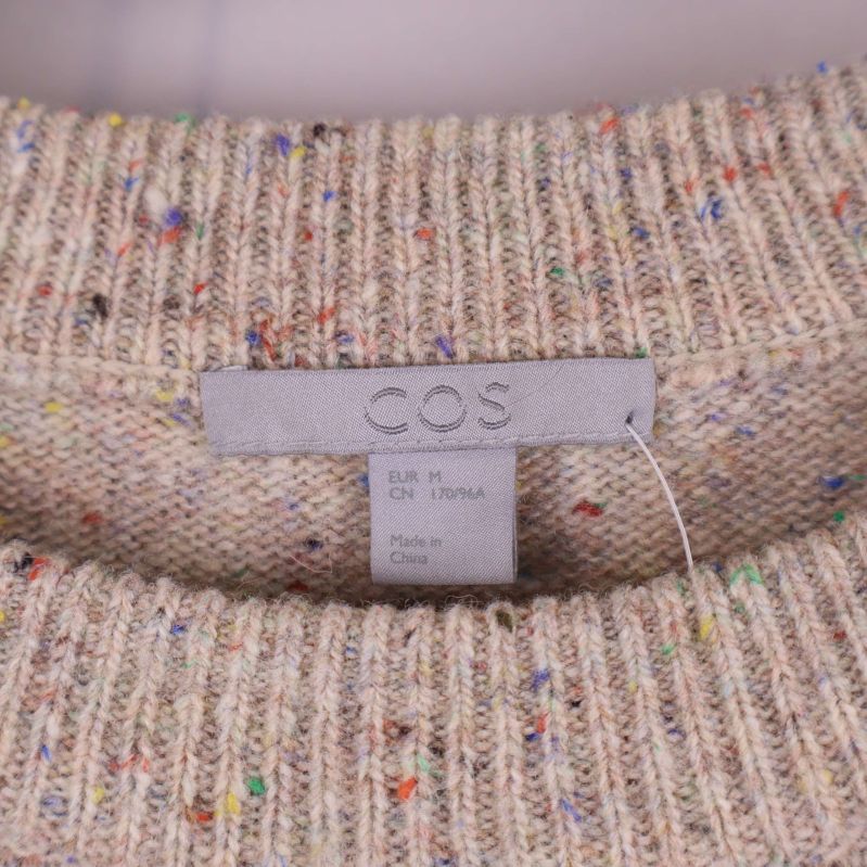 Närbild på cos logotyp i halsen på tröjan