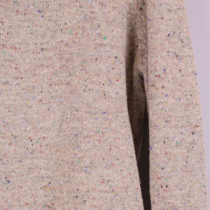 Stickat tyg med färgade prickar i närbild