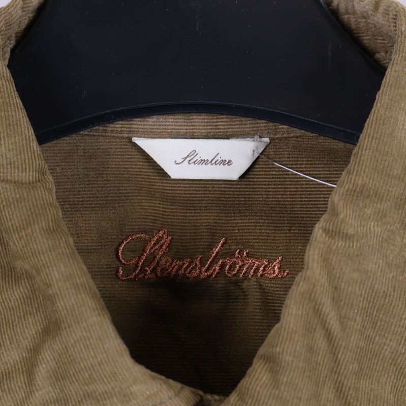 Närbild på krage och etikett där det står Slimline samt broderat varumärke