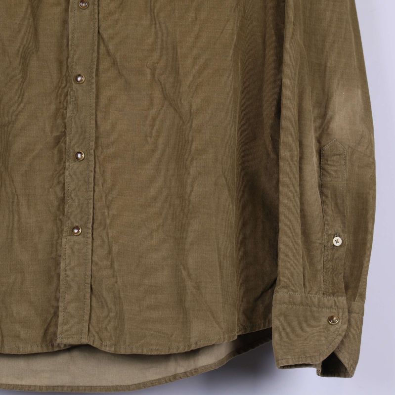 Nedre del av skjortan med ärmslut och bruna knappar