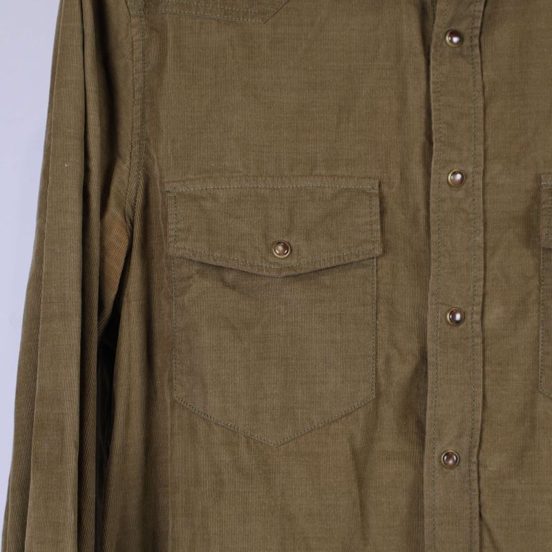 Detaljerad bild på bröstficka och knappar i bronsfärg