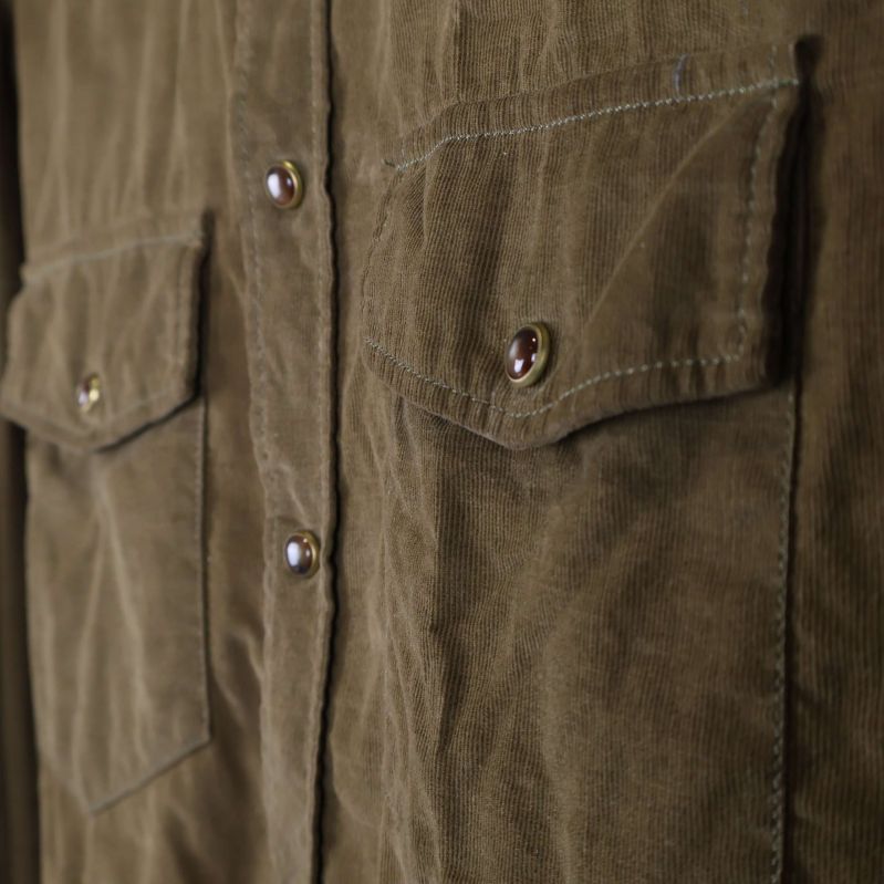 Närbild på tygstruktur och ena bröstfickan i manchester