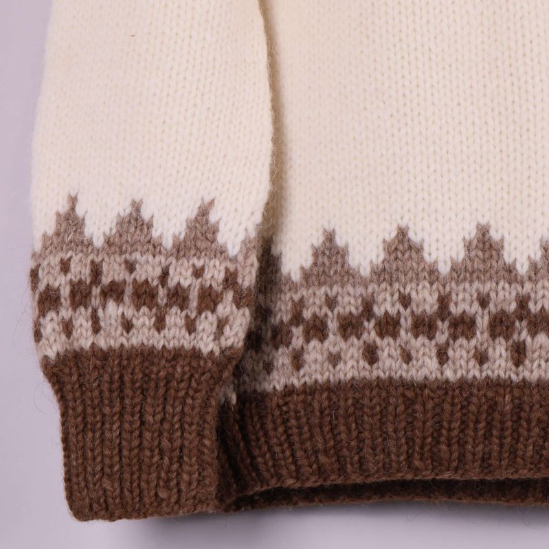 Närbild på tröjans ärmslut och nederkant med mönster