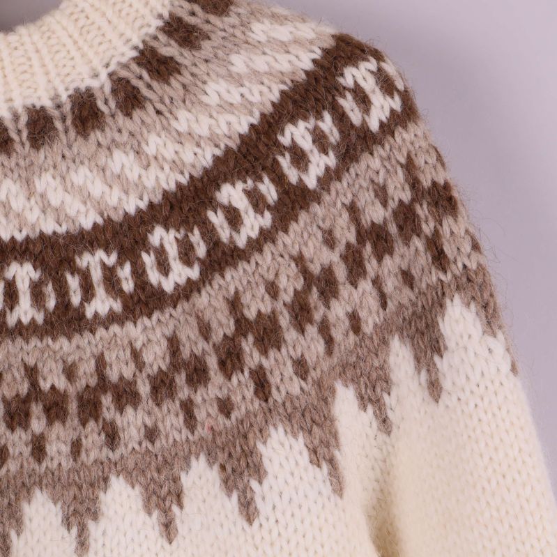 Närbild på tröjans ok med brunt och beige mönster