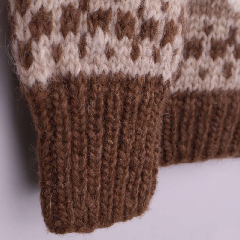 Närbild på tröjans stickade brunvit mudd