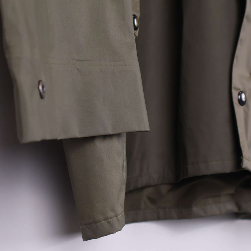 Detalj på ärmslut med tryckknapp på olivgrön jacka