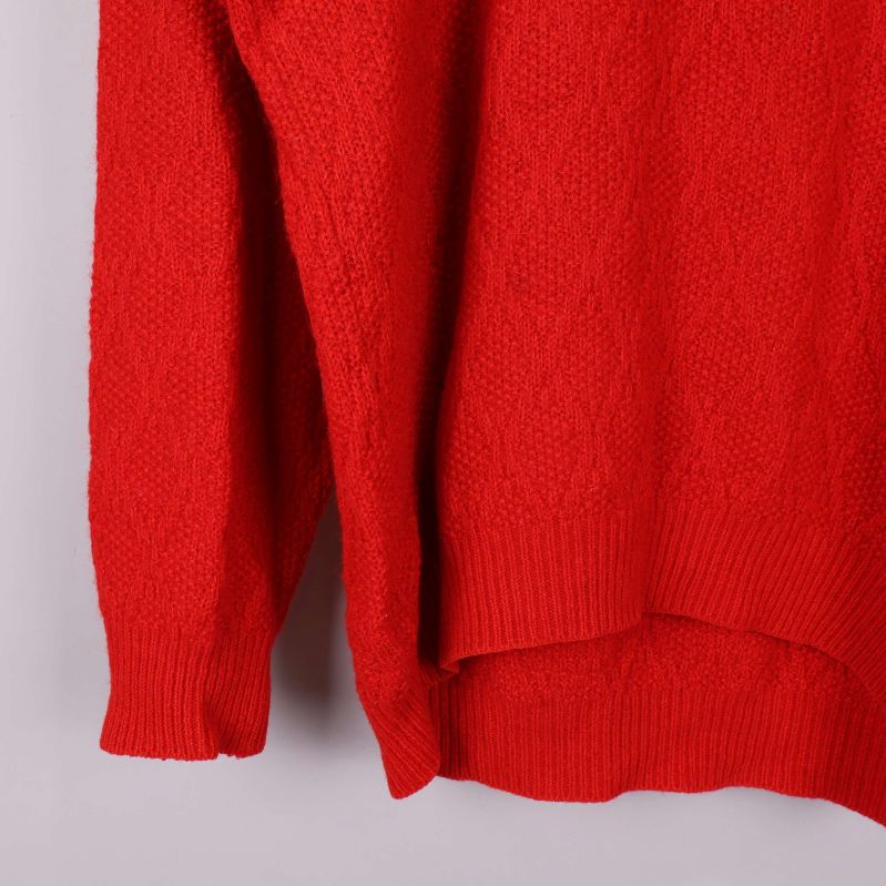 Detalj av nederkant och ärm på röd tröja