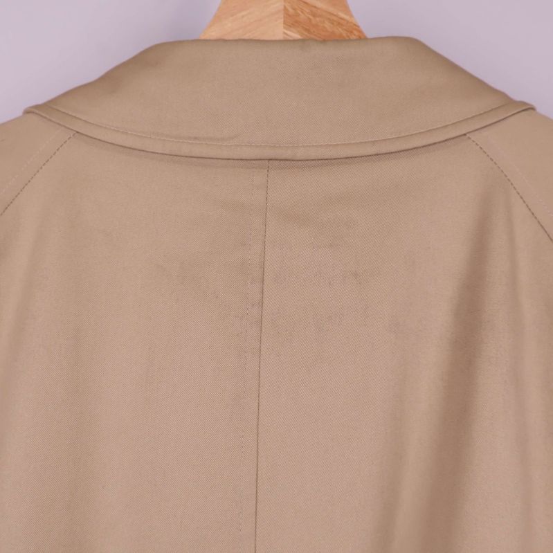 Närbild av krage och axlar på trenchcoat med fläck