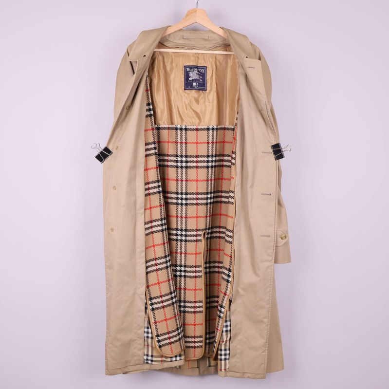 Trenchcoaten uppknäppt visar rutigt foder