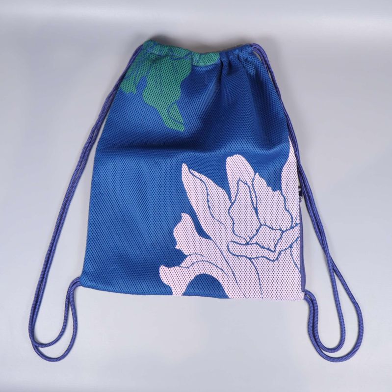 Baksida av blå gymnastikpåse med rosa blommor