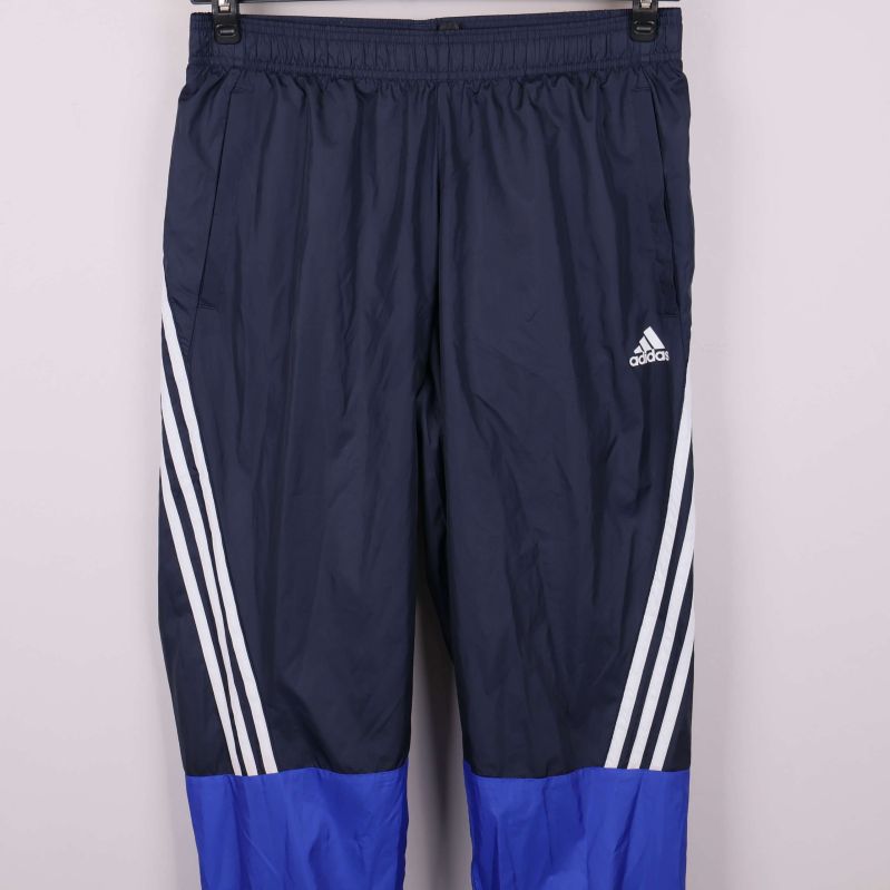 Närbild av träningsbyxor med adidas-logga och vita ränder