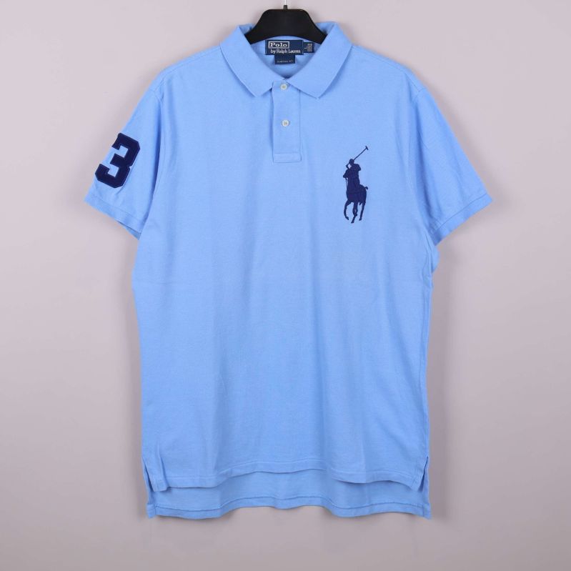 Ljusblå pikétröja med stor logotyp framtill